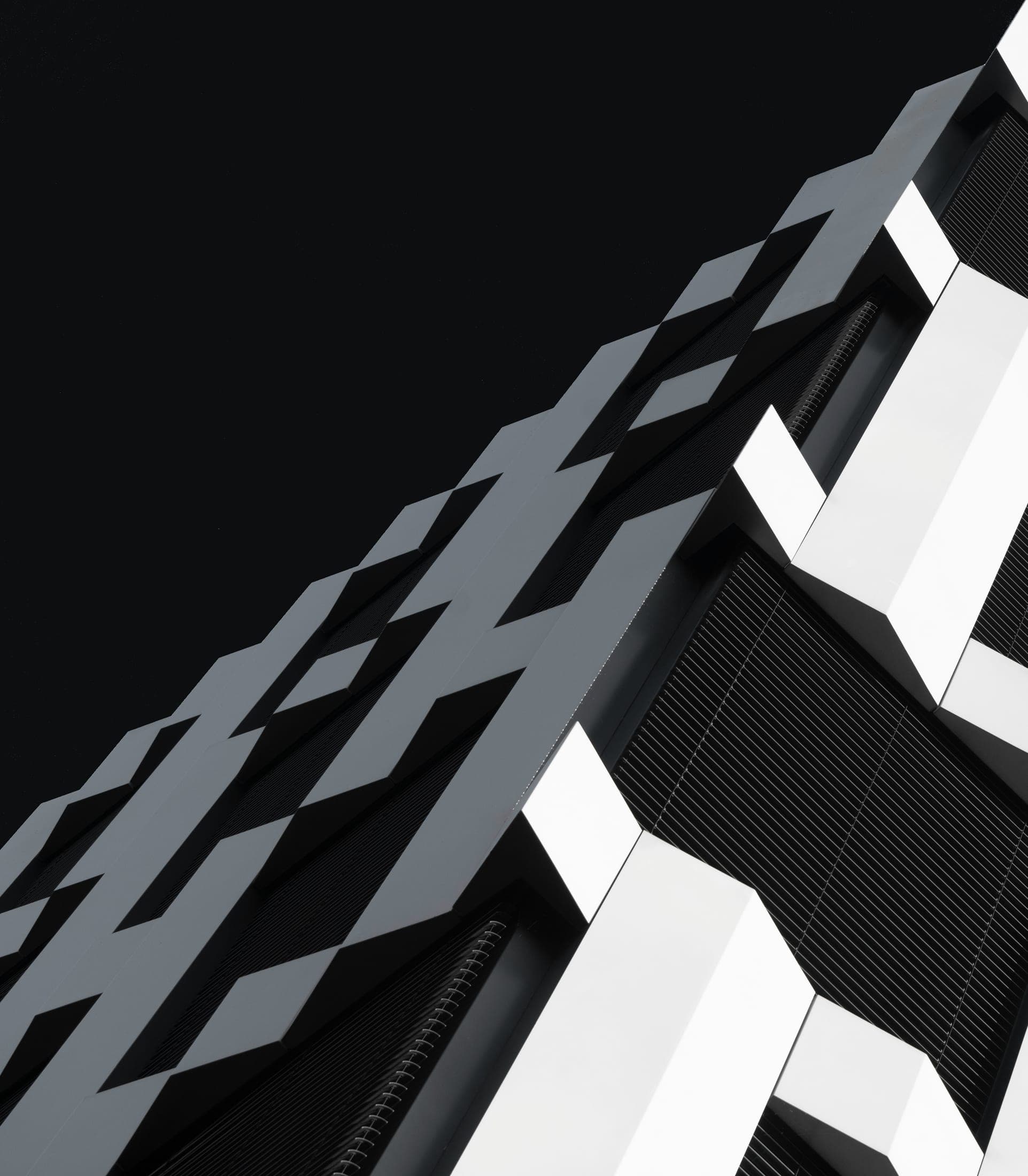 Façade en zigzag, contraste noir et blanc marqué.
